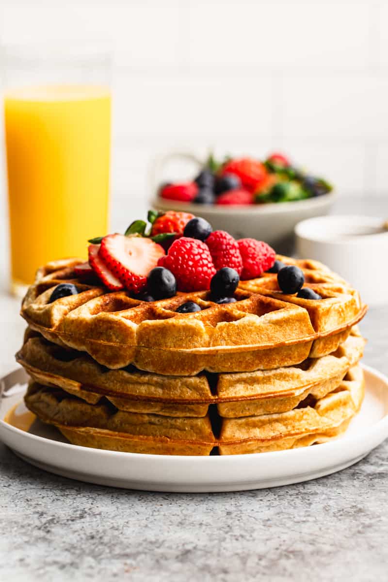 A stack of healthy Protein Waffles, topped with fresh berries.