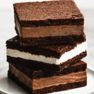 Three homemade Ice Cream Sandwiches, two of them with chocolate ice cream and one vanilla, stacked on top of each other, ready to enjoy.