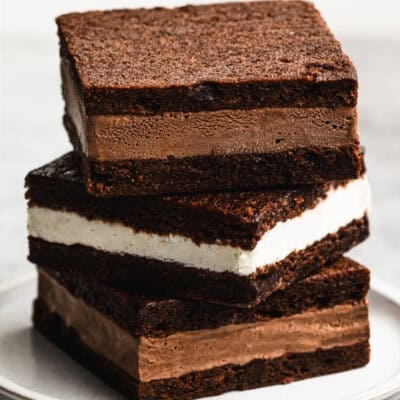 Three homemade Ice Cream Sandwiches, two of them with chocolate ice cream and one vanilla, stacked on top of each other, ready to enjoy.