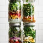 Four Mason Jar Salad recipes in jars, stacked on top of each other.