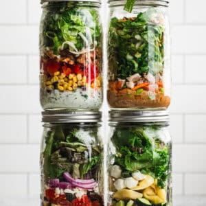 Four Mason Jar Salad recipes in jars, stacked on top of each other.