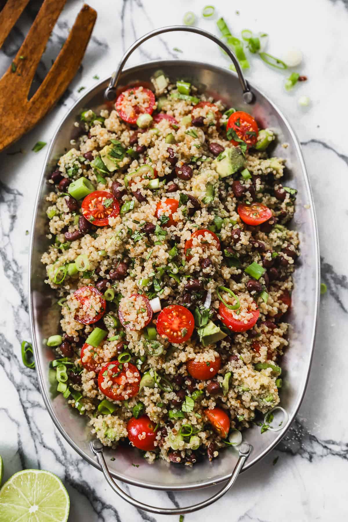 Quinoa Salad made with black beans, tomato and avocado, served in an oval serving dish. 