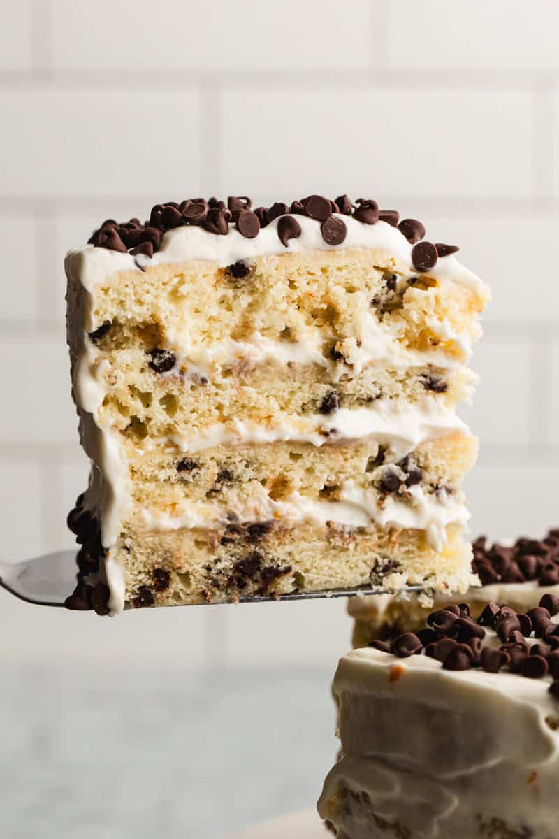 An easy Cannoli Cake recipe with a slice lifted up to show the layers. 