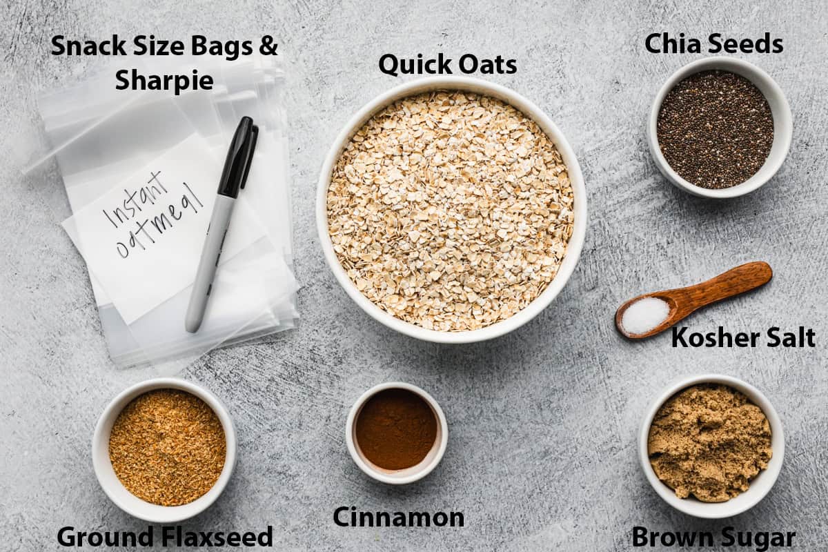 Oatmeal packets ingredients all laid out and measured: quick oats, chia seeds, ground flaxseed, cinnamon, brown sugar, salt, and single serve bags. 