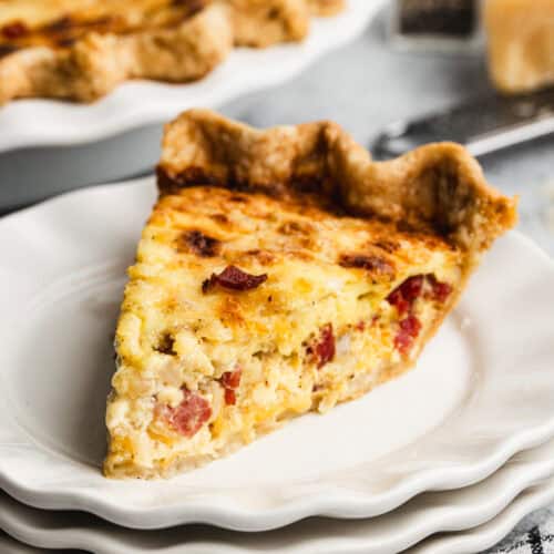 A slice of the best Quiche Lorraine made with bacon, onion, and plenty of cheese. Cooked until golden, ready to eat.