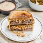 The best Patty Melt on sourdough bread, cut in half and stacked on top, ready to eat.