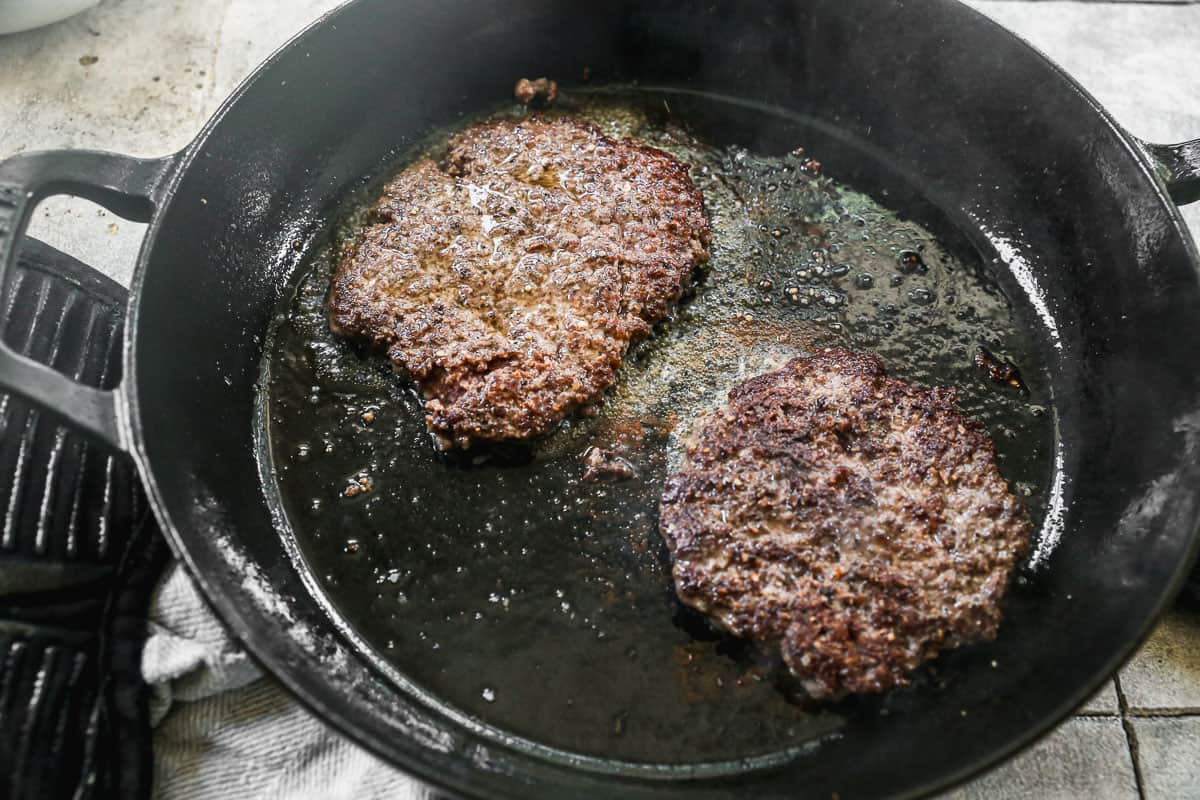 Two images showing two burger patties being cooked on a cast iron pan for a homemade patty melt. 