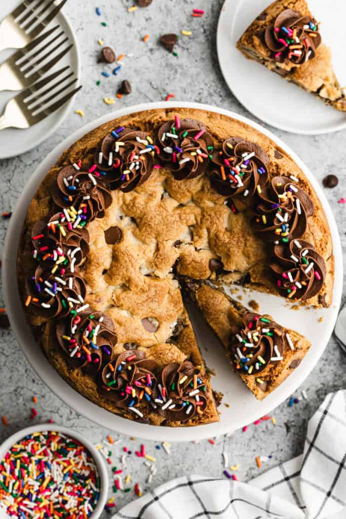 This Chocolate Chip Cookie Cake recipe is quick and easy to make at home and has that irresistible soft and chewy center! More affordable and tastes better than store-bought!