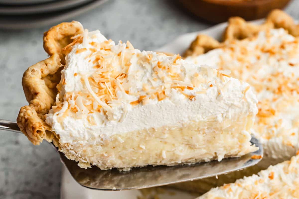 This easy Coconut Cream Pie recipe has a creamy homemade custard filling and is topped with fresh whipped cream and golden toasted coconut.