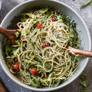 A creamy Pesto Pasta recipe with spaghetti tossed in a homemade pesto sauce then mixed with fresh tomatoes, arugula, and parmesan cheese.