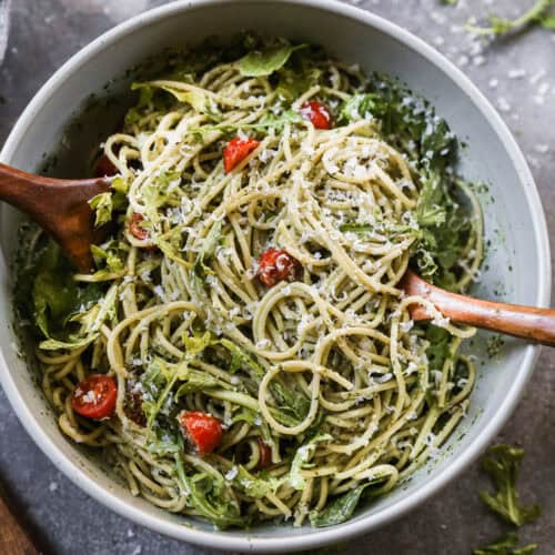 A creamy Pesto Pasta recipe with spaghetti tossed in a homemade pesto sauce then mixed with fresh tomatoes, arugula, and parmesan cheese.