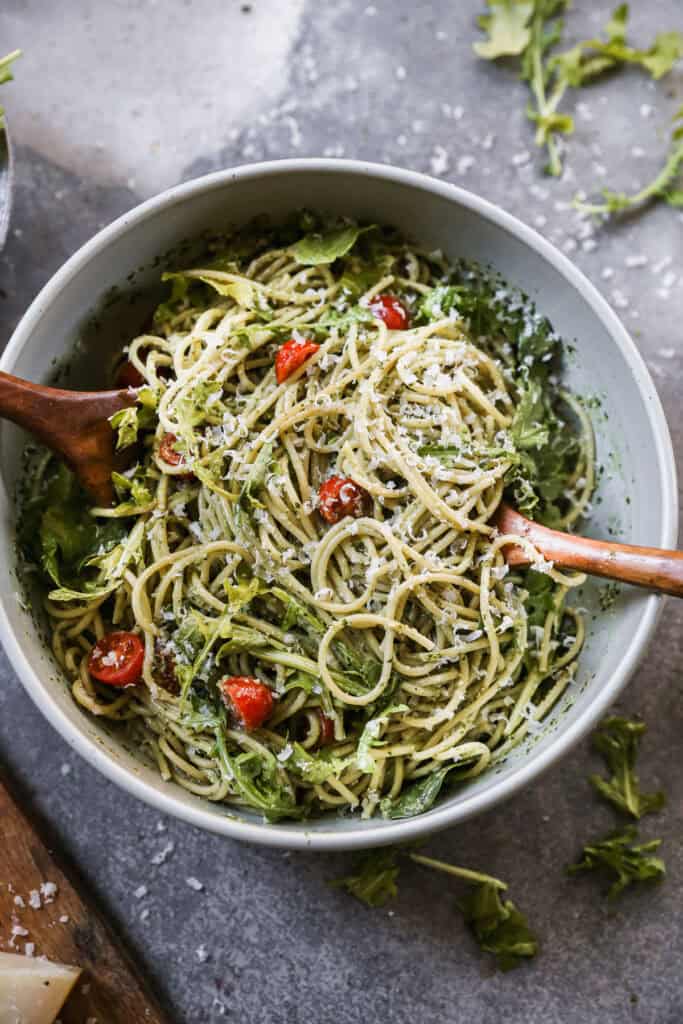 A creamy Pesto Pasta recipe with spaghetti tossed in a homemade pesto sauce then mixed with fresh tomatoes, arugula, and parmesan cheese.