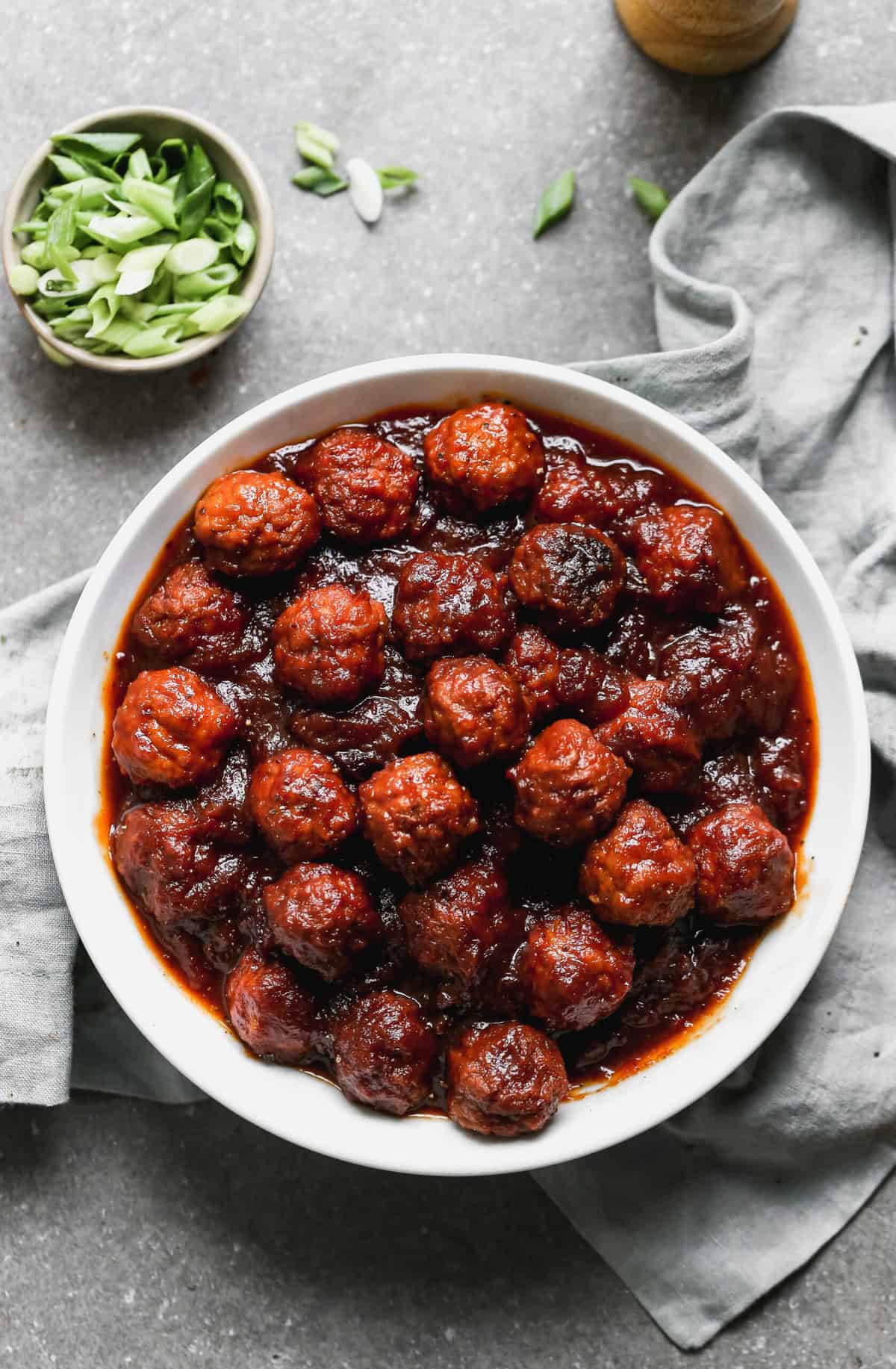 A white bowl filled with slow cooker bbq meatballs.