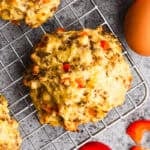 A homemade Breakfast Biscuits recipe made with eggs, cheese and sausage on a wire cooling rack.