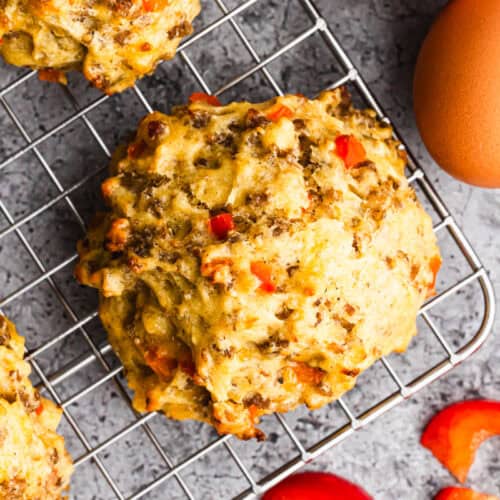A homemade Breakfast Biscuits recipe made with eggs, cheese and sausage on a wire cooling rack.