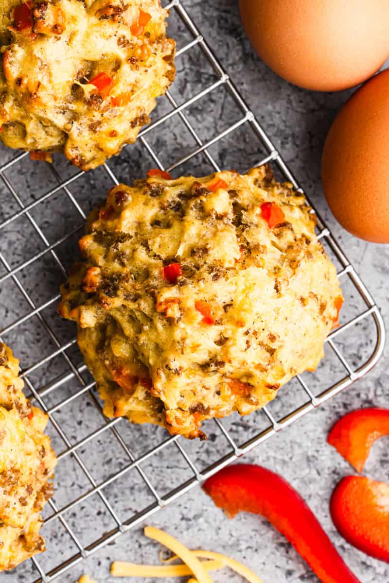 A homemade Breakfast Biscuits recipe made with eggs, cheese and sausage on a wire cooling rack.