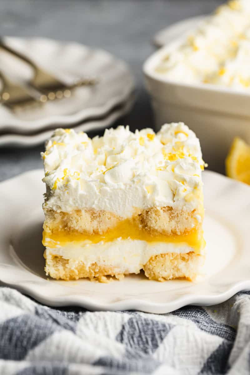 A piece of an easy lemon tiramisu dessert on a white plate, showing the delicious layers. 
