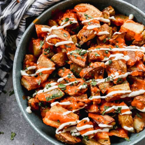 An easy Patatas Bravas recipe with crispy potatoes, bravas sauce, and a garlic aioli served in a bowl.
