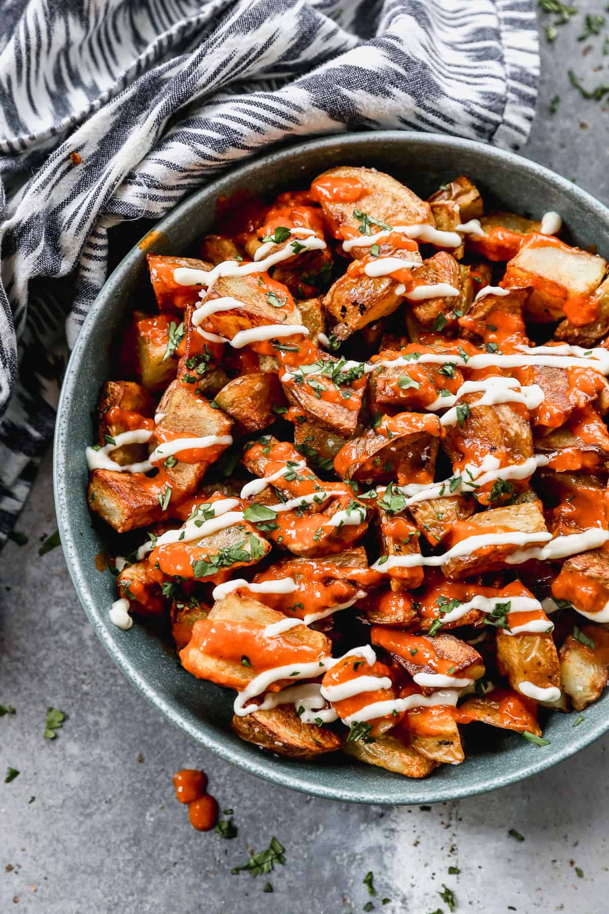 An easy Patatas Bravas recipe with crispy potatoes, bravas sauce, and a garlic aioli served in a bowl.