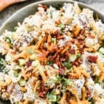 This loaded baked potato salad is the perfect make-ahead side dish, topped with cheese, bacon, and green onions for the ultimate crowd-pleaser.