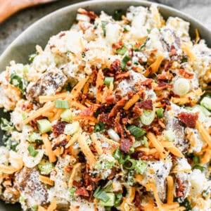 This loaded baked potato salad is the perfect make-ahead side dish, topped with cheese, bacon, and green onions for the ultimate crowd-pleaser.