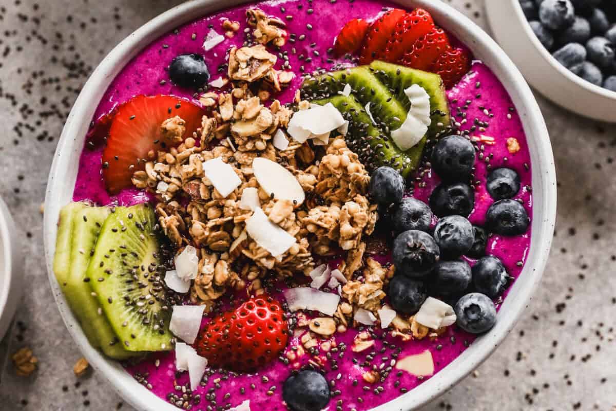 Easy Pitaya Bowls are made in the blender in just 5 minutes and is flavorful and refreshing and topped with granola, coconut, and fresh fruit. It's any picky eaters favorite!