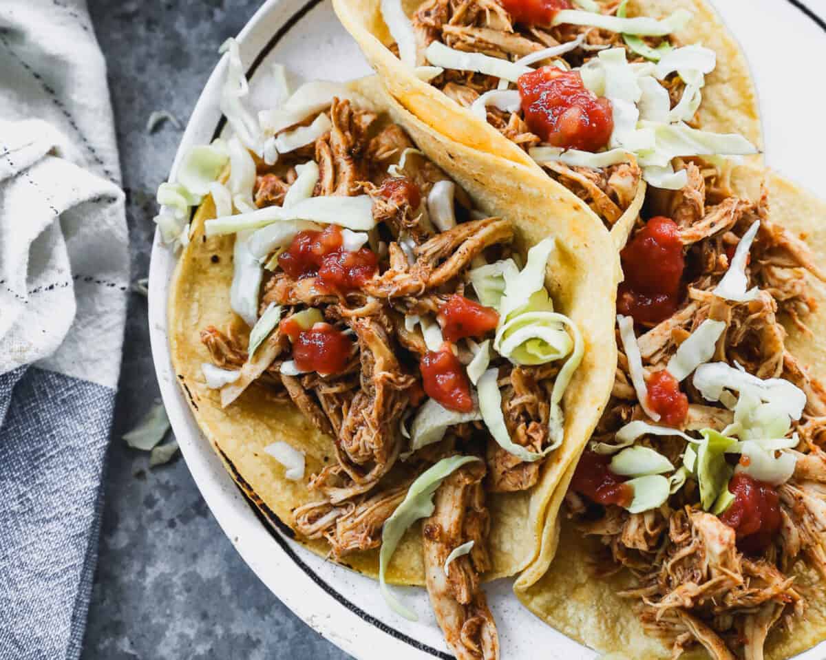 A plate of Slow Cooker Chicken Tacos ready to enjoy with the most delicious meat that can be meal prepped and used in a variety of dishes all week!