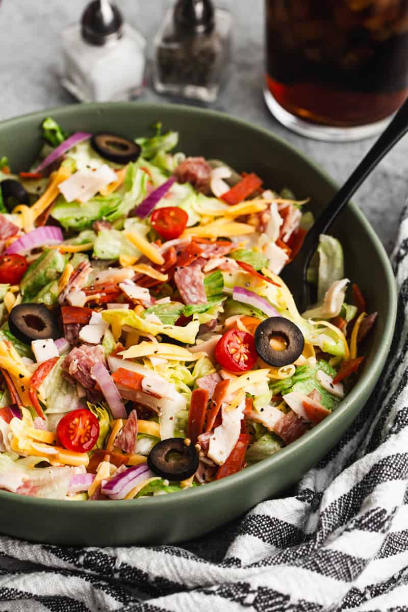 This Italian Grinder Chopped Salad is packed with salty deli meats, crisp chopped lettuce, tangy olives, and creamy cheese tossed in zesty dressing.