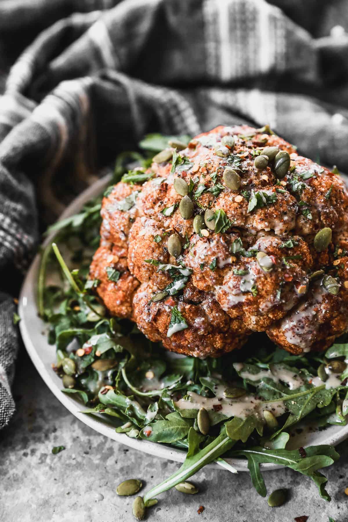 This whole roasted cauliflower is seasoned well and served with a creamy tahini sauce.