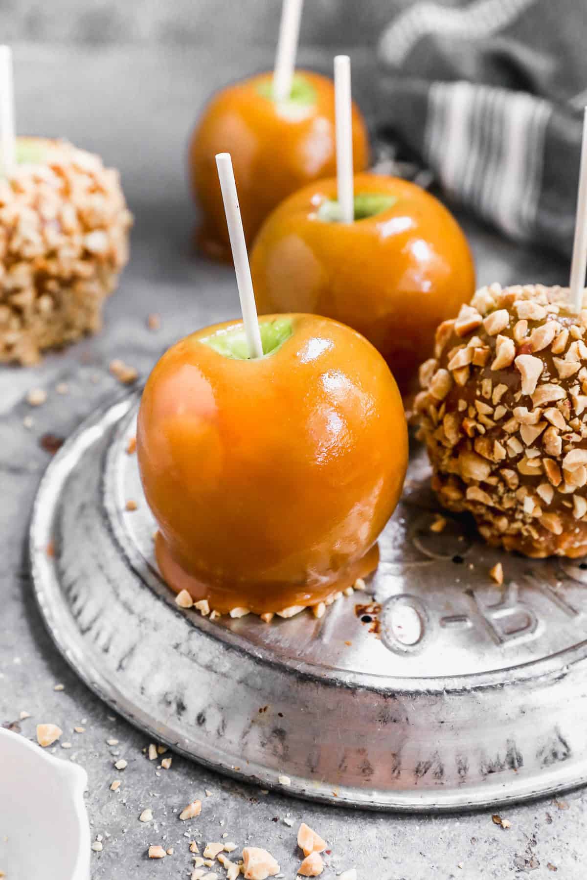 These Caramel Apples bring fall fair vibes home with rich caramel coating and customizable toppings.