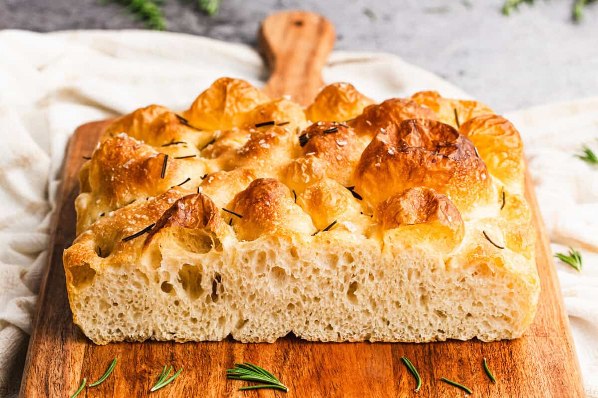 This homemade focaccia recipe is fluffy inside with crisp edges and can be topped with herbs, olives, or tomatoes for endless variations.
