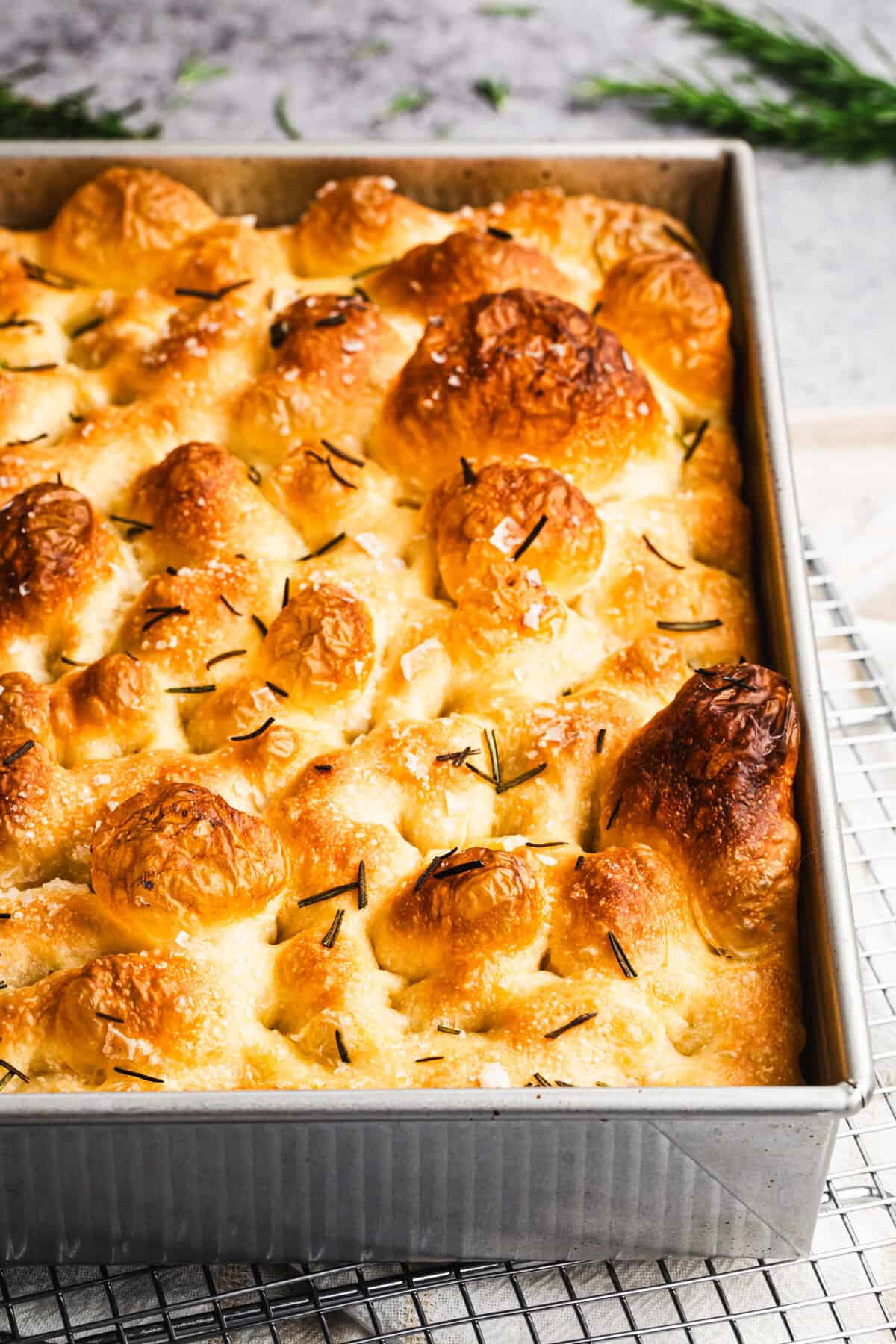 This homemade focaccia recipe is fluffy inside with crisp edges and can be topped with herbs, olives, or tomatoes for endless variations.