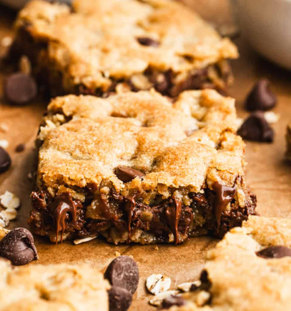 Homemade Oatmeal Chocolate Chip Bars cut into squares on parchment paper, ready to enjoy.