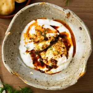 This easy Turkish Eggs recipe has perfectly poached eggs on a bed of lemon garlic yogurt, topped with a drizzle of a quick spiced chili butter.