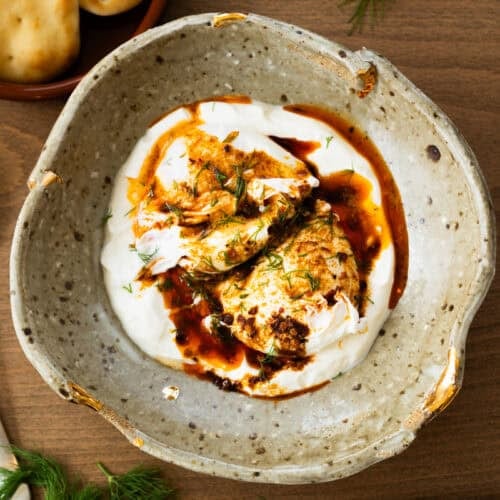 This easy Turkish Eggs recipe has perfectly poached eggs on a bed of lemon garlic yogurt, topped with a drizzle of a quick spiced chili butter.