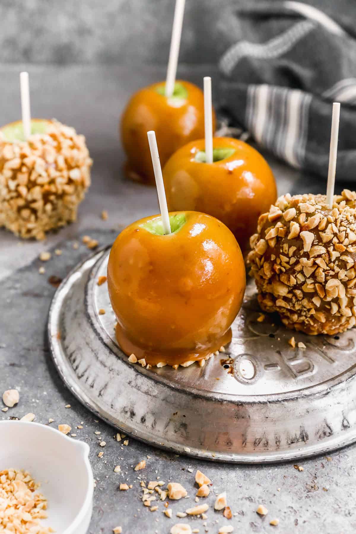 Homemade caramel apples are a classic fall favorite and perfect for Halloween party prep with kids.