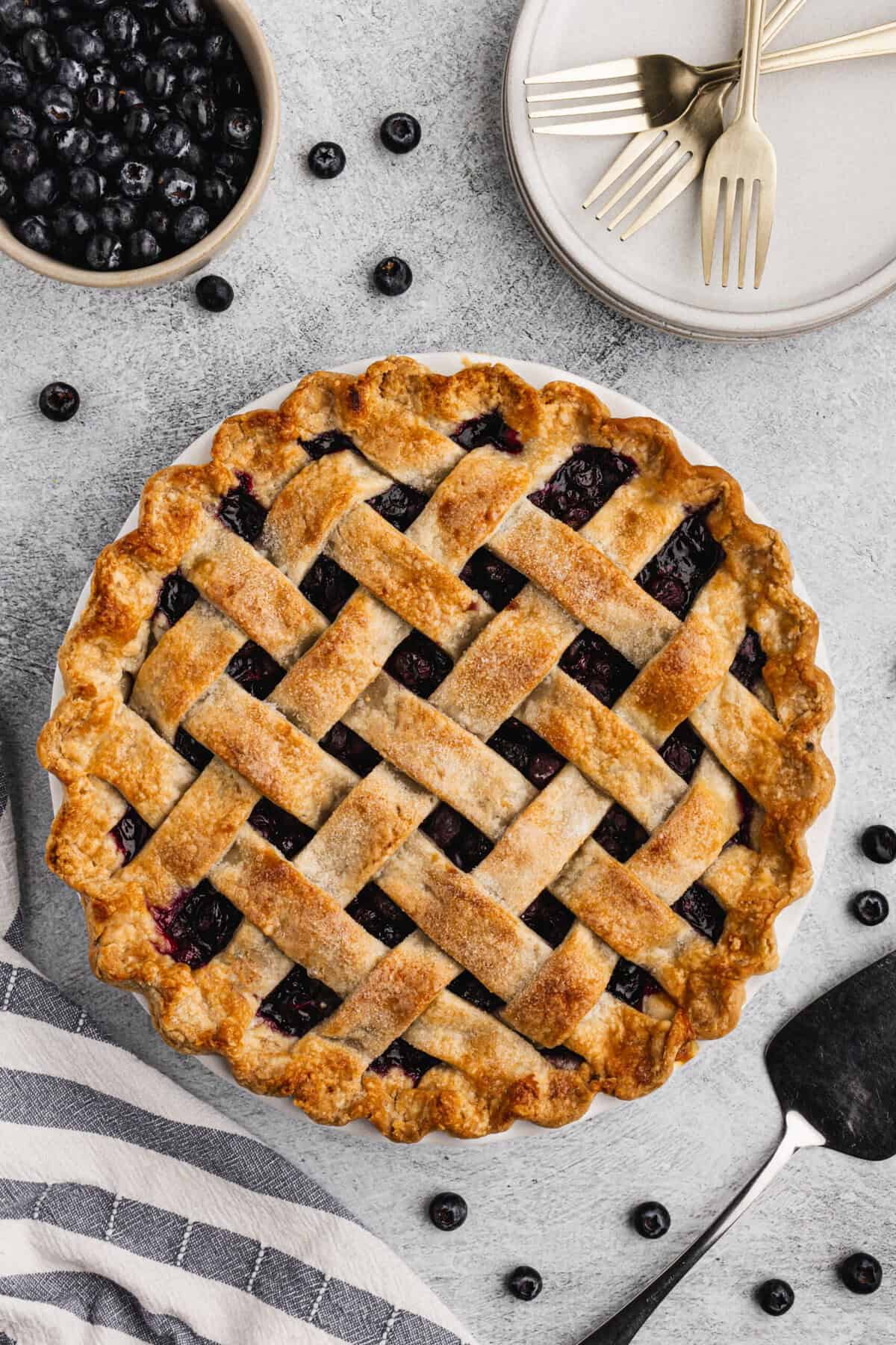 This classic blueberry pie recipe features a golden lattice crust and juicy filling that is perfect for any holiday gathering. 