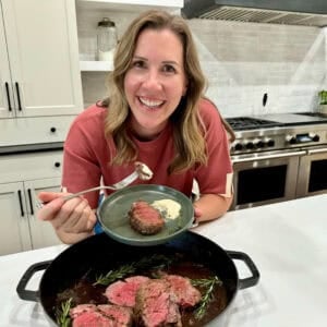 Lauren Allen with a plate of Beef Tenderloin that is perfectly cooked and being dipped in an orange-infused horseradish sauce.