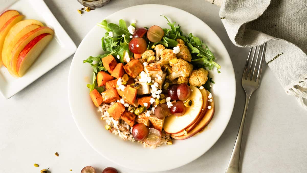 This easy Nourish Bowl recipe is loaded with roasted chicken and veggies then topped with apples, grapes, pistachios, and goat cheese. Use my quick balsamic vinaigrette to compliment it perfectly. 