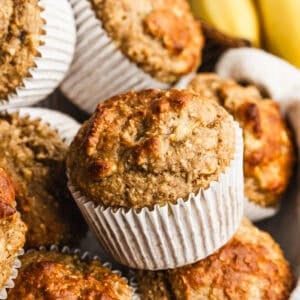 This high protein banana muffins recipe is healthy and packed with oats, bananas, greek yogurt, protein powder, and sweetened with maple syrup. They are moist, fluffy, and keep you full longer!