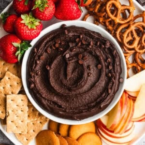This easy Chocolate Hummus recipe is a healthier dessert that tastes just as indulgent as anything! Dip whatever fruit, crackers, or cookies you'd like for the ultimate party dip!