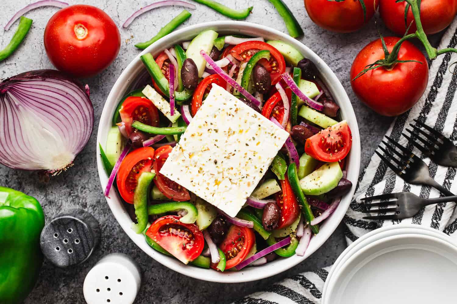 This easy Greek Salad recipe is bursting with flavor from fresh vegetables coated in a little bit of olive oil, vinegar, and seasonings. It's delicious and so quick!