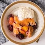 This easy Peach Blackberry Cobbler recipe is bursting with fresh fruit under a golden and buttery topping. Enjoy it year round with fresh or canned peaches.