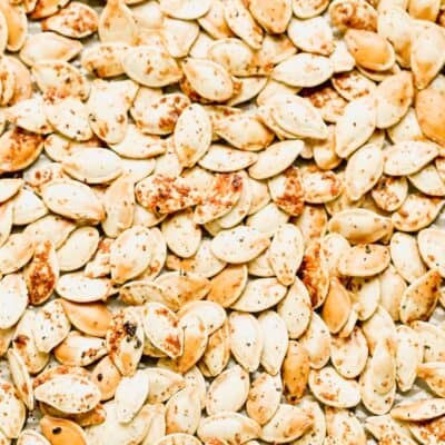 Golden roasted pumpkin seeds seasoned with salt and cayenne on a baking sheet